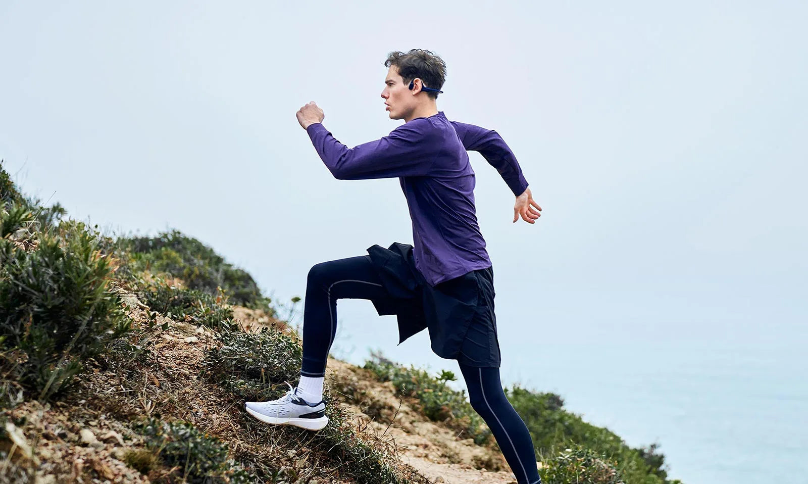 man-runs-outdoors-with-HaptiFit-Terra-open-ear-headphone-desktop