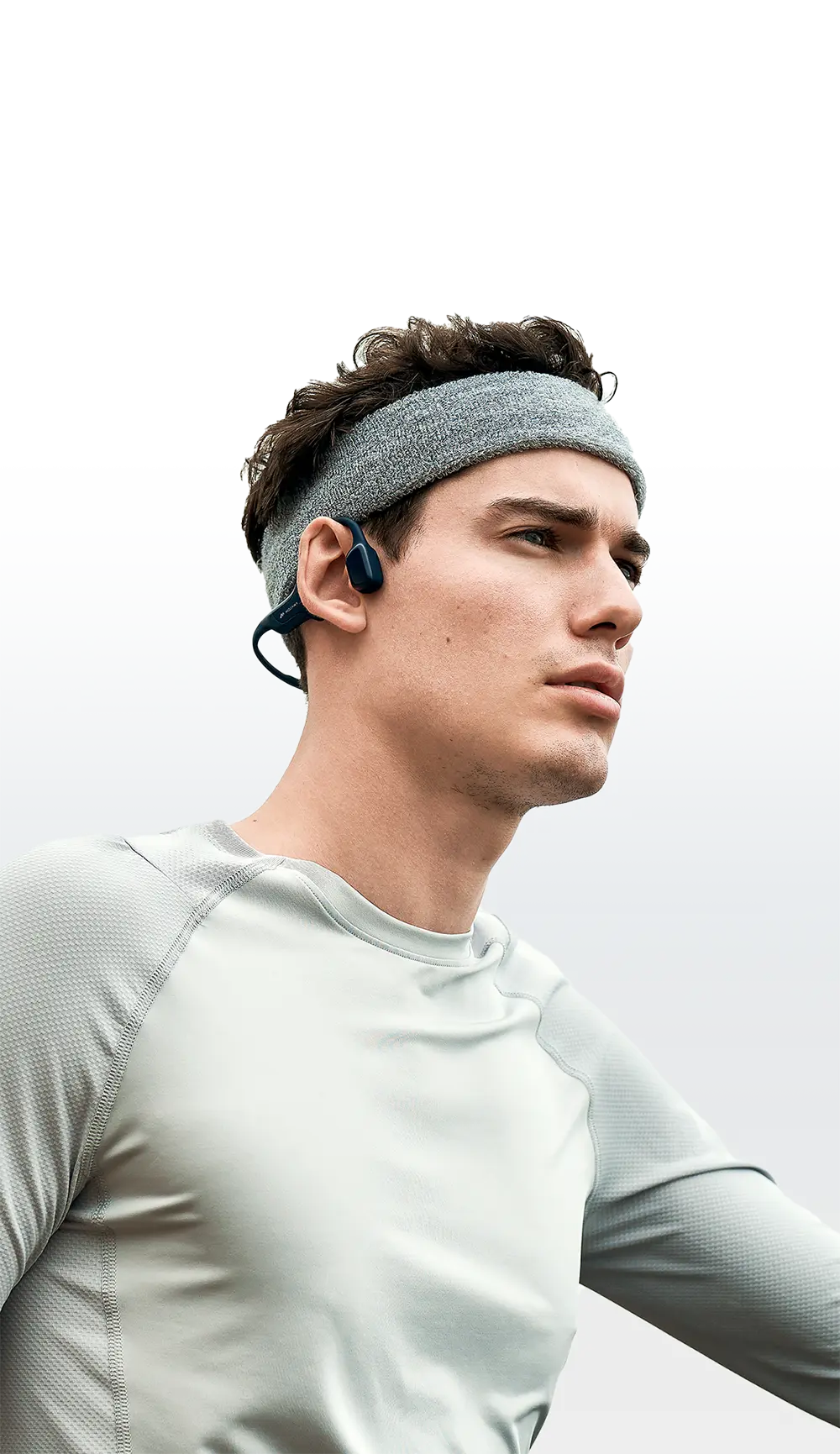 man-wears-HaptiFit-Terra-open-ear-headphone-mobile